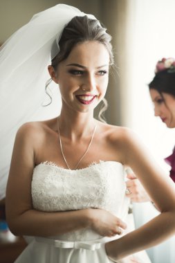 Beyaz elbiseli lüks gelin düğün törenine hazırlanırken poz veriyor.