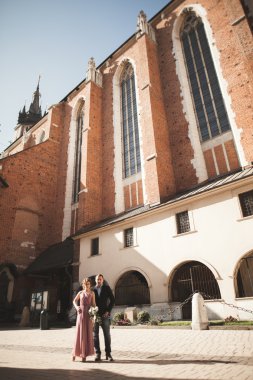 Muhteşem Düğün çifti, damat ve gelin pembe elbise Krakow eski şehirde yürüyüş ile