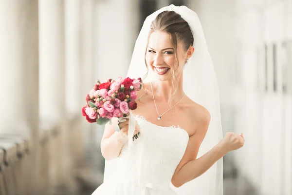 Maravillosa novia con un lujoso vestido blanco posando en el casco antiguo —  Fotos de Stock