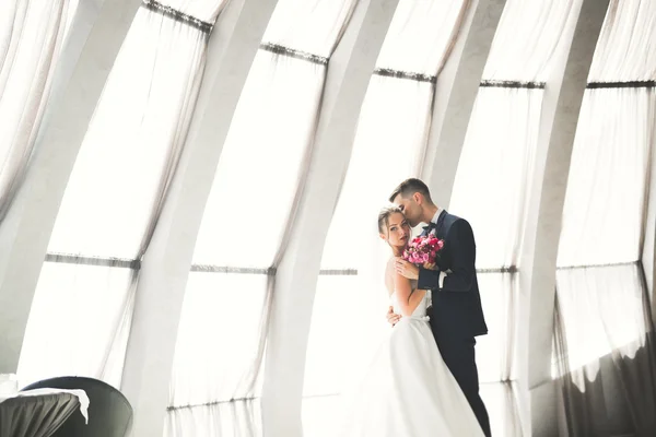 Casal feliz encantador do casamento, noiva com vestido branco longo posando na cidade bonita — Fotografia de Stock