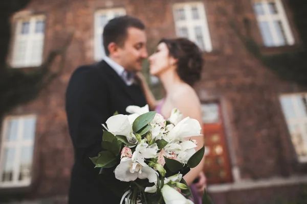 背景に新婚カップルと結婚式の花花束 — ストック写真