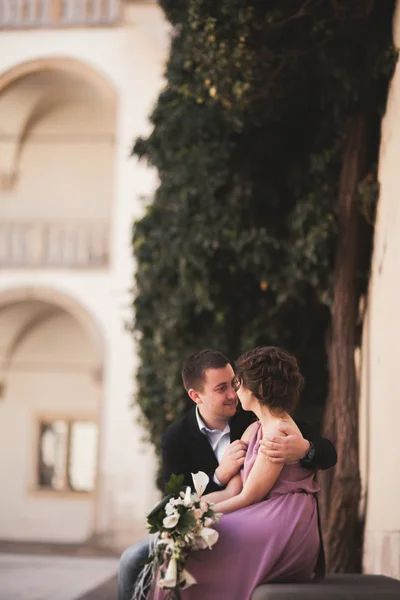快乐婚礼夫妇、 新郎、 新娘与粉红色的连衣裙拥抱和微笑彼此的背景墙在城堡里 — 图库照片