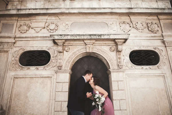 Splendida coppia di nozze, sposo e sposa con abito rosa passeggiando nella città vecchia di Cracovia — Foto Stock