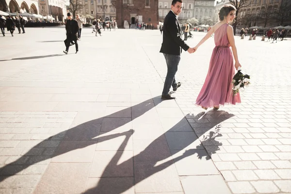 Bröllop. vackert par, brud med rosa brudklänning promenad i den gamla staden Krakow, deras skuggor — Stockfoto