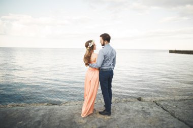 Güzel sevgi dolu çift, gurur iskelede yürüyüş uzun elbise ile