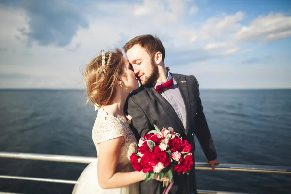 Marié couple marchant sur la plage au coucher du soleil . — Photo