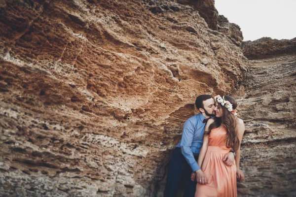 Romántica pareja amorosa caminando por la playa con rocas y piedras — Foto de Stock