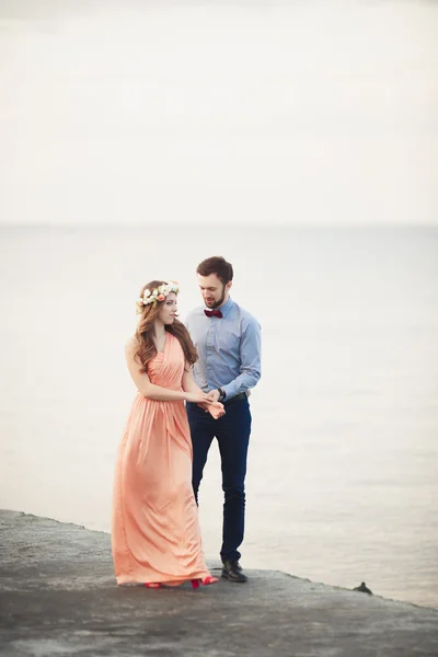 Couple marié debout sur un quai au-dessus de la mer — Photo