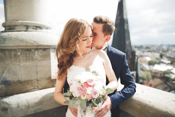 Elegante hermosa pareja de boda besándose y abrazándose en el fondo vista panorámica del casco antiguo — Foto de Stock