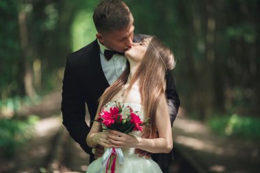 Genç düğün çift, gelin ve damat bir demiryolundan poz