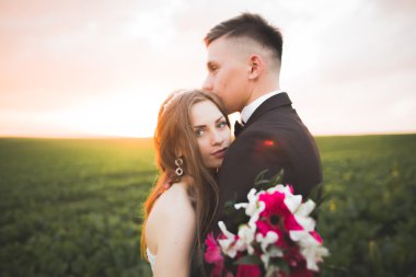 Güzel düğün çift, aşk günbatımı üzerinde. Fielf çiçekli