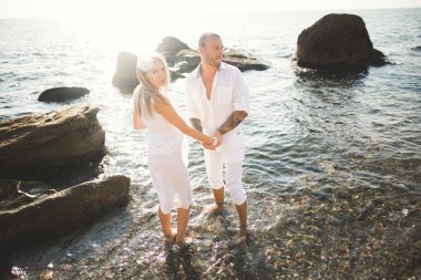 Deniz, mavi gökyüzü yakınındaki taş poz romantik sevgi dolu Çift