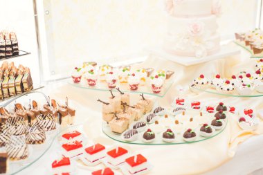 Çeşitli lezzetli tatlılar, yemek fikirleri ve kutlamalarla dolu bir büfe.