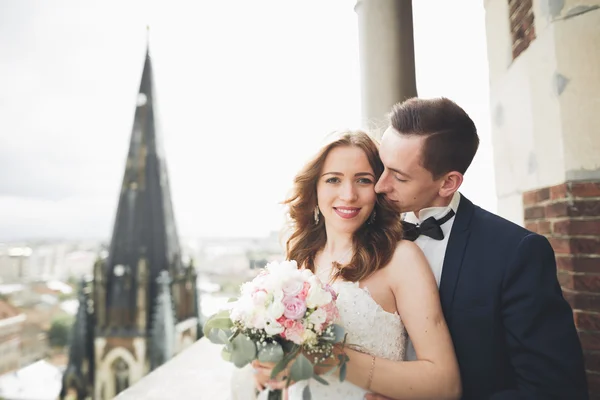 スタイリッシュな美しい結婚式のカップルキスと抱擁上の背景パノラマビューの旧市街 — ストック写真