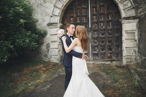 Hermosa boda romántica pareja de recién casados abrazos cerca del viejo castillo —  Fotos de Stock