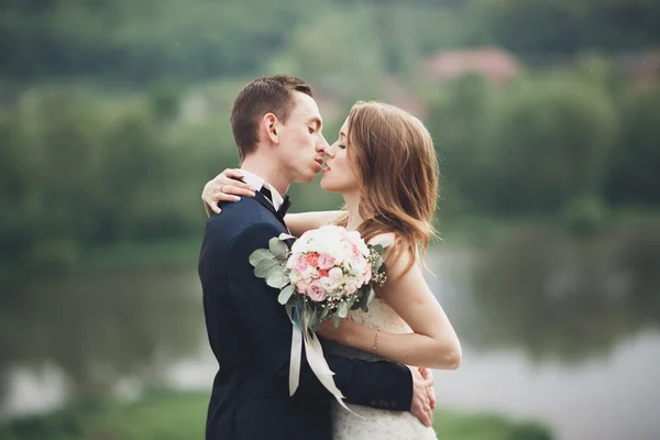 Romantické svatební pár, muž a žena, představuje v blízkosti krásného jezera — Stock fotografie