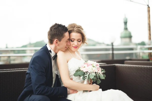 Appena sposati coppia di nozze posa e sposa tenendo in mano bouquet — Foto Stock