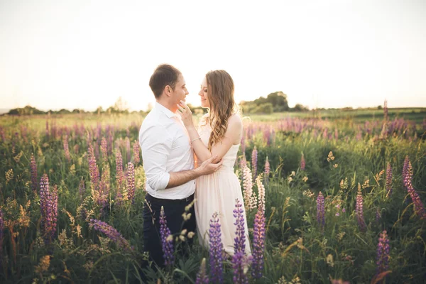 Bella sposa emotiva che abbraccia lo sposo appena sposato da dietro il tramonto in un primo piano di campo — Foto Stock