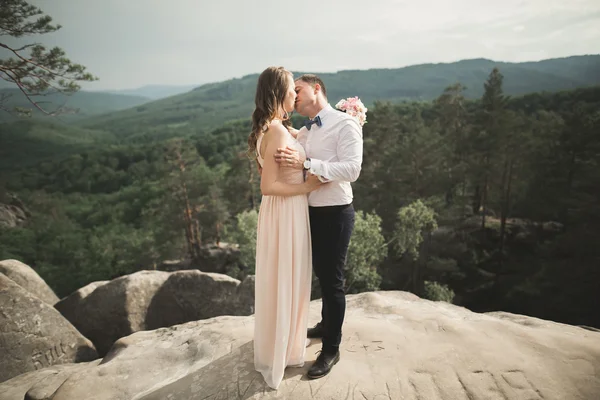 Magnifique mariée, marié embrasser et embrasser près des falaises avec une vue imprenable — Photo