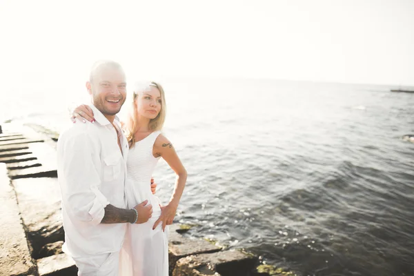 Casamento casal beijando e abraçando em rochas perto do mar azul — Fotografia de Stock