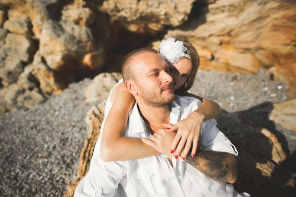 Giovani modelli coppia in posa sulla spiaggia con pietre — Foto Stock
