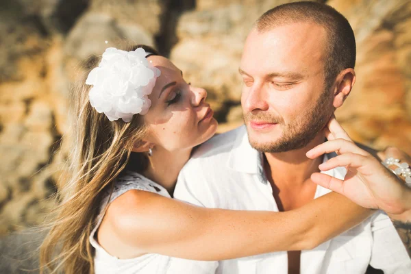 Young models couple posing on the beach with stones — Stock Photo, Image