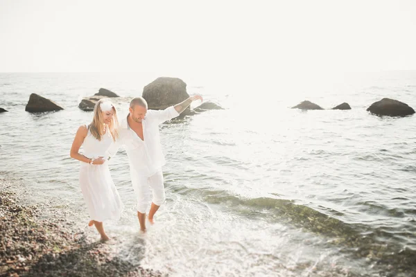 快乐只是结婚的年轻婚礼夫妇庆祝，美丽的海滩日落时有乐趣 — 图库照片