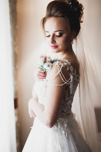 Noiva de luxo em vestido branco posando enquanto se prepara para a cerimônia de casamento — Fotografia de Stock