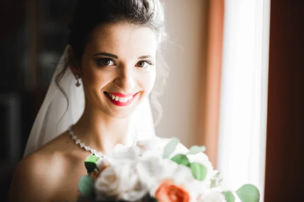 Mariée de luxe en robe blanche posant tout en se préparant pour la cérémonie de mariage — Photo