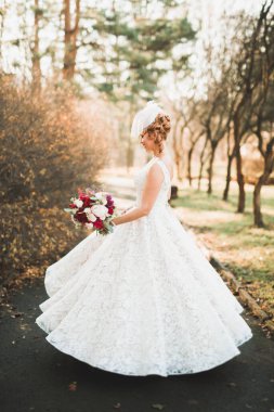 Parkta mükemmel bir elbiseyle dönen güzel gelin.