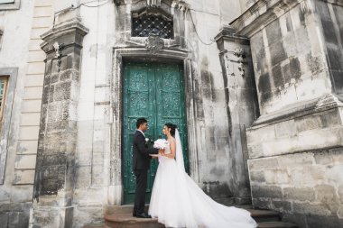 Sevgi dolu bir düğün çifti Lviv şehrinin sokaklarında yürüyor.