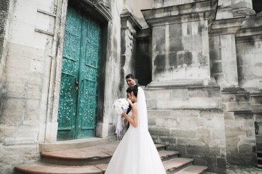 Doğadaki düğün çifti birbirine sarılıyor. Beyaz elbiseli güzel bir kız. Takım elbiseli adam