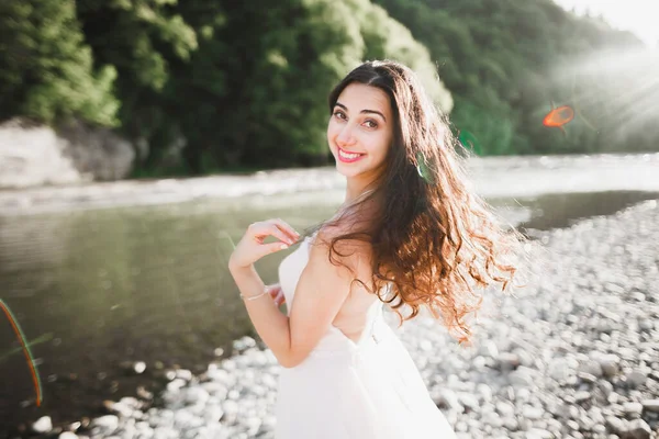 Portrait de mariée magnifique aux cheveux longs debout au bord de la rivière — Photo