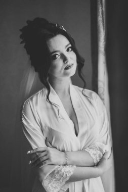 Beyaz elbiseli lüks gelin düğün törenine hazırlanırken poz veriyor.