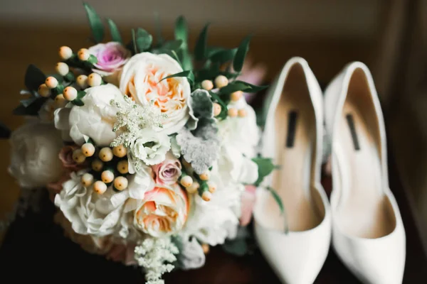 Brides wedding shoes with a bouquet with roses and other flowers — 图库照片