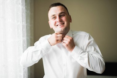 Güzel adam, damat poz veriyor ve düğüne hazırlanıyor.