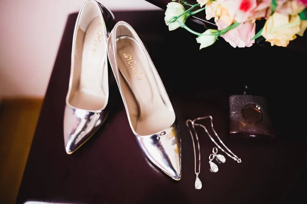 Νύφες παπούτσια γάμου και κοσμήματα κοστουμιών με μπουκέτο με τριαντάφυλλα και άλλα λουλούδια. — Φωτογραφία Αρχείου