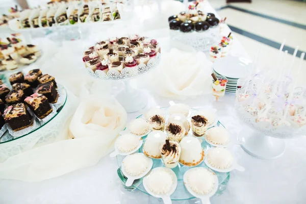 Deliciosa e saborosa mesa de sobremesa com cupcakes e tiros no closeup da recepção — Fotografia de Stock