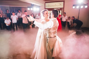 Güzel bir düğün çifti yeni evlendi ve ilk danslarını ediyorlar.