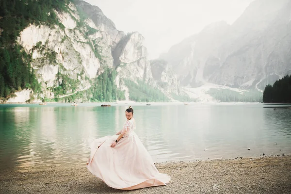 Krásná nevěsta vystupují skály pozadí pohoří — Stock fotografie