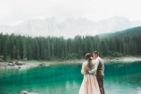 Красива сучасна пара біля озера в горах робить весільні фотографії — стокове фото