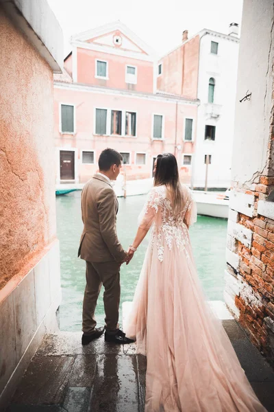 Pareja de boda cogidos de la mano, novio y novia juntos el día de la boda en Venecia, Italia — Foto de Stock