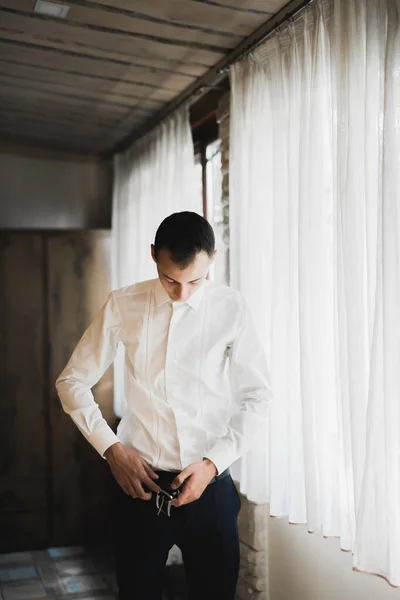 Preparação de manhã de noivos. Bonito homem se vestir e se preparando para o casamento — Fotografia de Stock