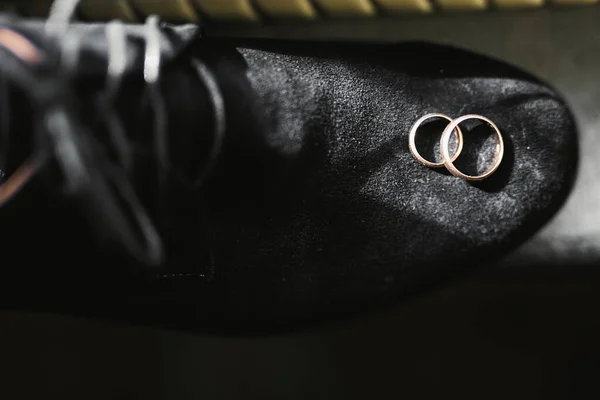 Et sett med mannssko med to gylne gifteringer. – stockfoto