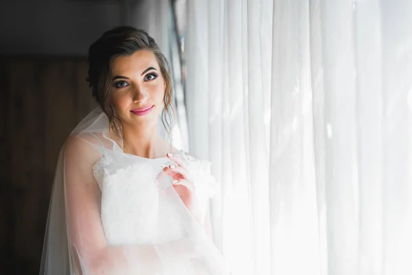 Splendida sposa in accappatoio in posa e preparazione per la cerimonia di nozze faccia in una stanza — Foto Stock