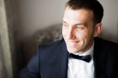 Güzel adam, damat poz veriyor ve düğüne hazırlanıyor.