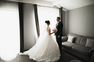 Göz kamaştırıcı mutlu çift birbirine yakın duruyor ve gözlerinin içine bakıyor.