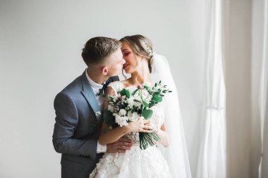 Güzel gelin ve damat düğün günlerinde kucaklaşıp öpüşürler.