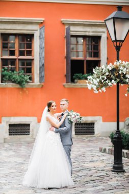 Doğadaki düğün çifti birbirine sarılıyor. Beyaz elbiseli güzel bir kız. Takım elbiseli adam