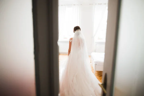 Mempelai wanita cantik mengenakan gaun pengantin dengan bulu dengan riasan mewah dan gaya rambut, studio pemotretan dalam ruangan — Stok Foto